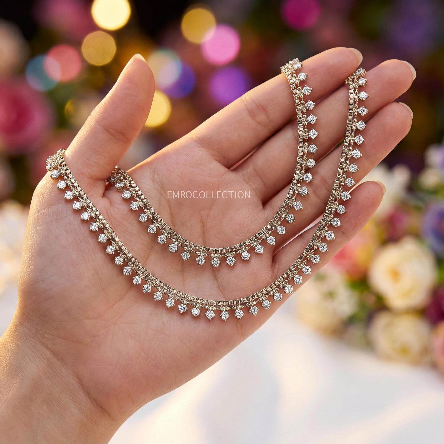 antique golden anklets held in a hand with a blurred floral background - trending pakistani jewellery