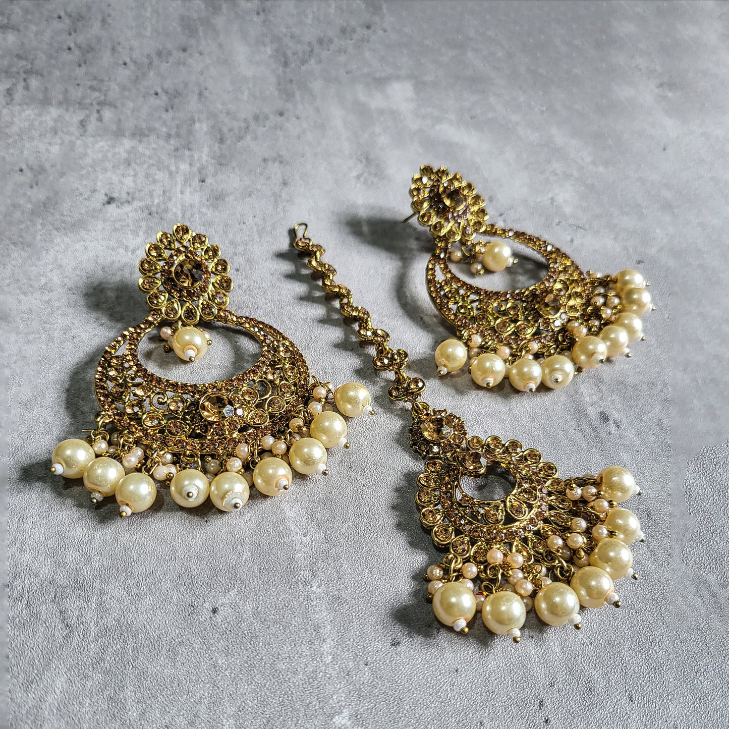 golden earrings and a mang tikka set