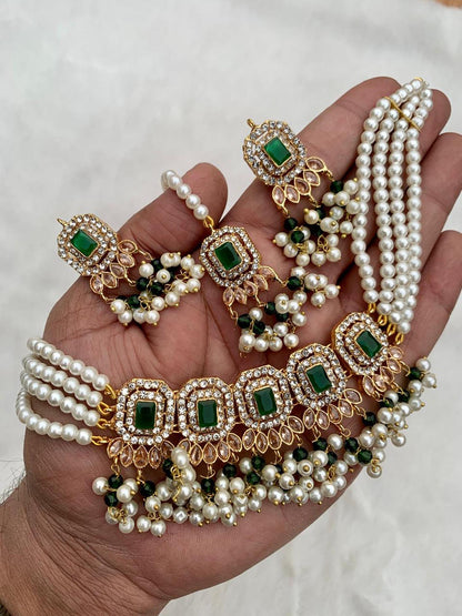 Hand holding a simple green pakistani choker set on a white background
