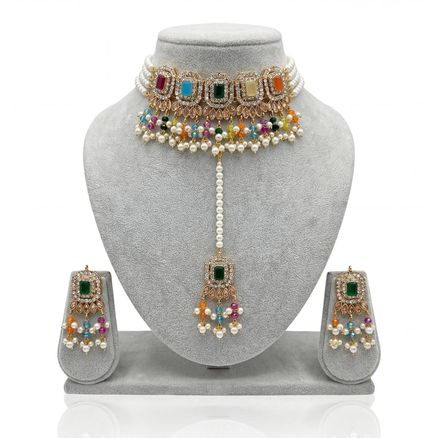 the nine-piece multi choker necklace set with earrings and maang tikka spread out for viewing