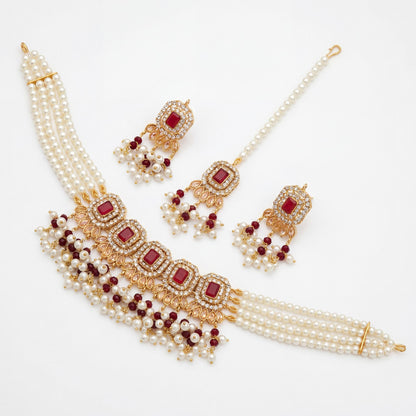 Jewelry set with pearls and red stones on a white background Pakistani jewellery