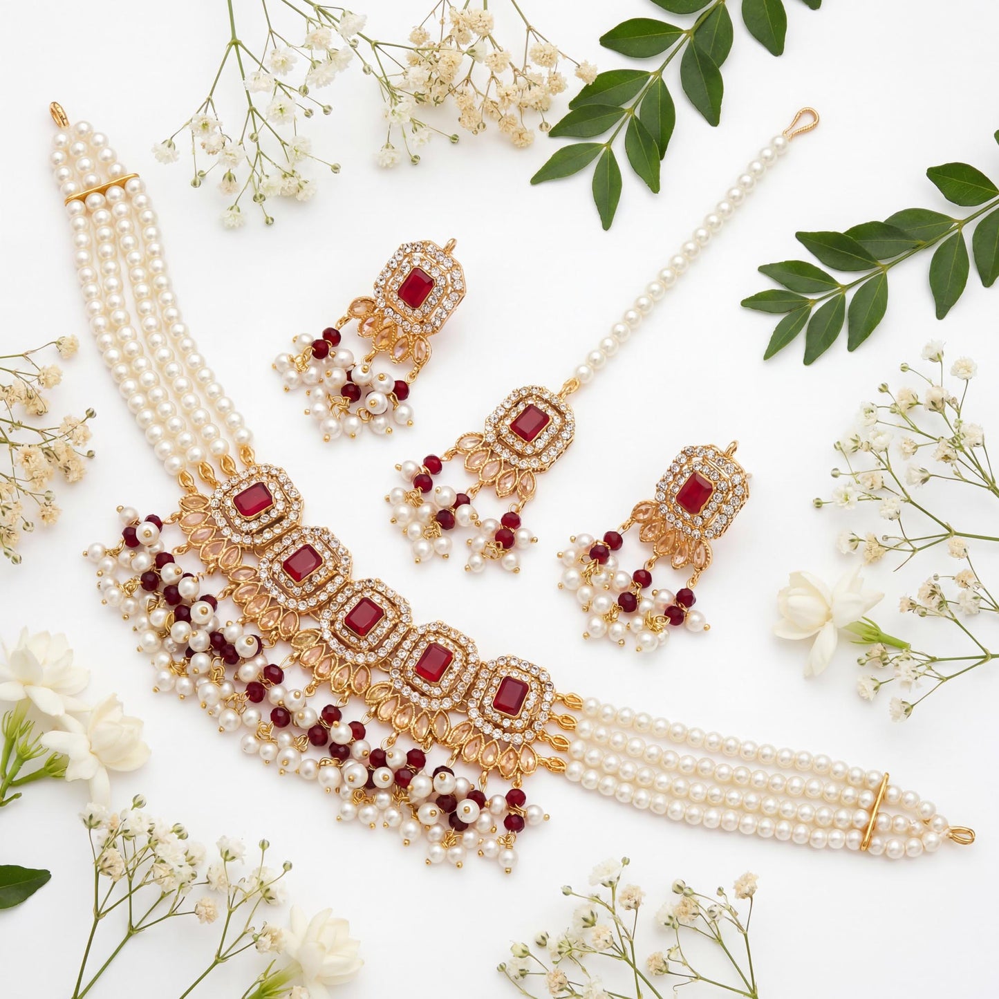 jewelry set with pearls and maroon stones on a white background with flowers and leaves pakistani jewellery