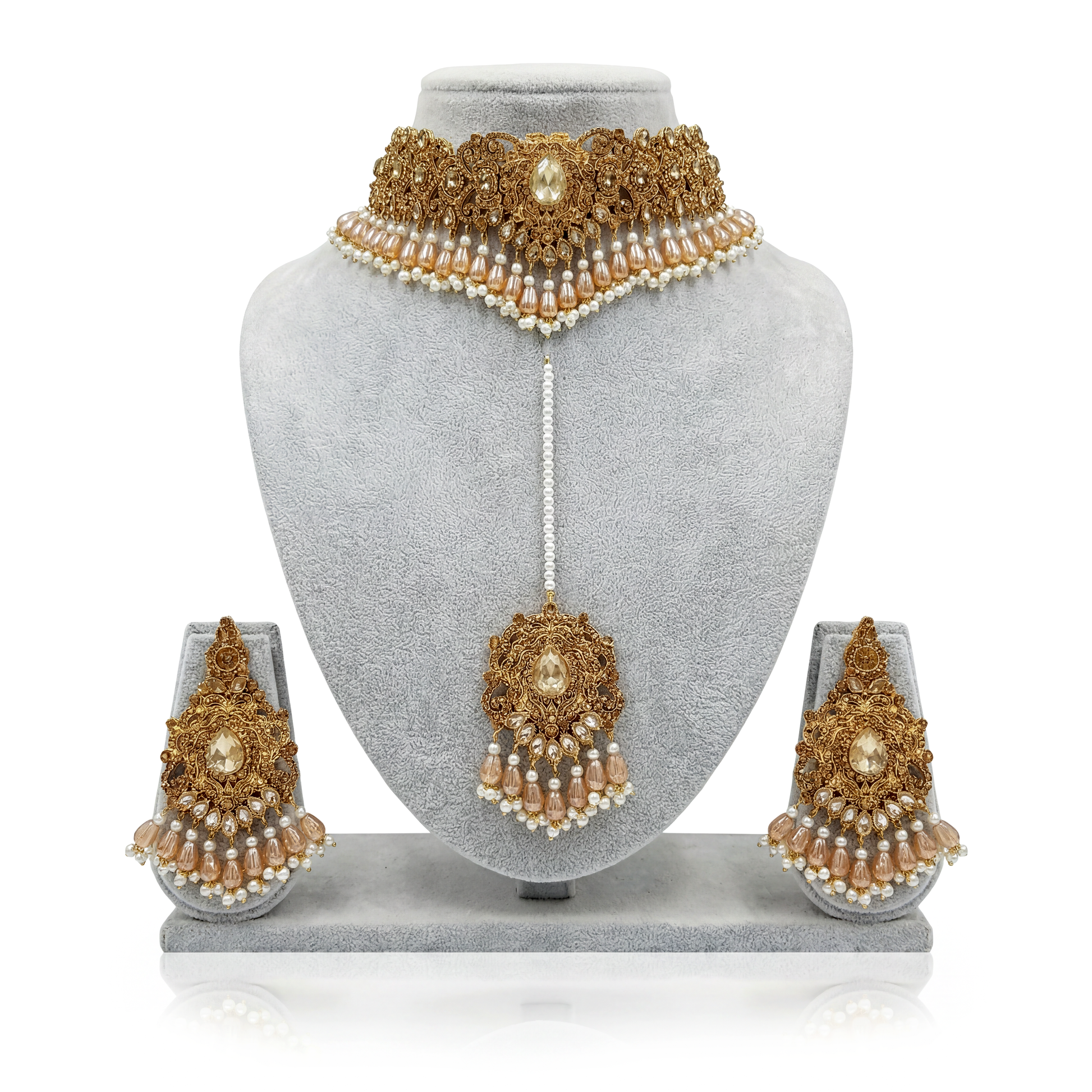 Pakistani Gold and pearl bridal jewelry set on a gray mannequin bust with earrings displayed below.