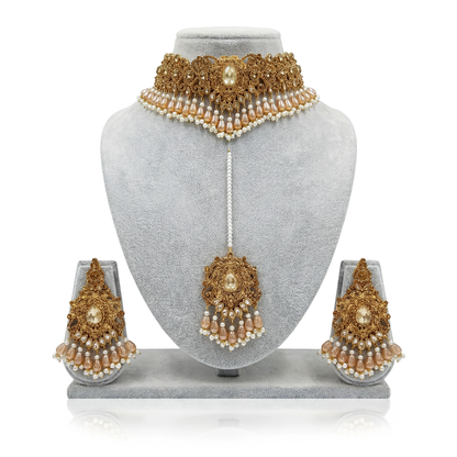 Pakistani Gold and pearl bridal jewelry set on a gray mannequin bust with earrings displayed below.