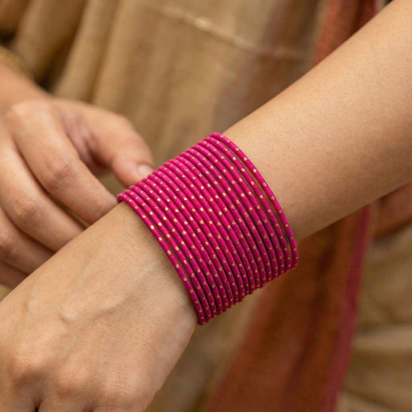 model wearing shocking pink bangles with golden dots churi set on wrist showing elegant indian bridal jewellery styling indian jewellery