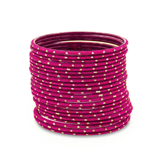 Shocking pink bangles with golden dots churi set stacked together showing slim elegant Indian jewellery design indian jewellery