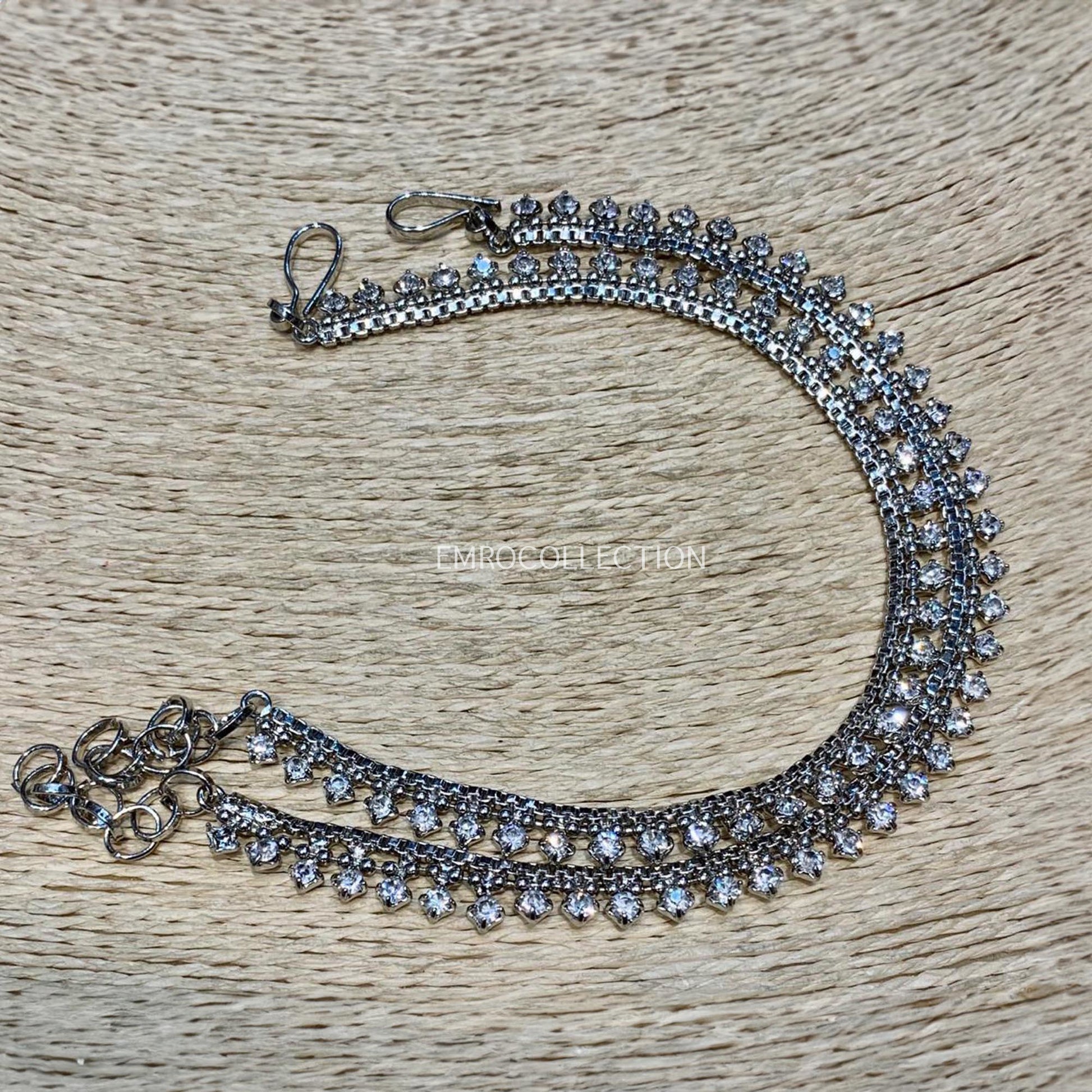 Silver anklets with gemstones on a wooden surface - Pakistani jewellery