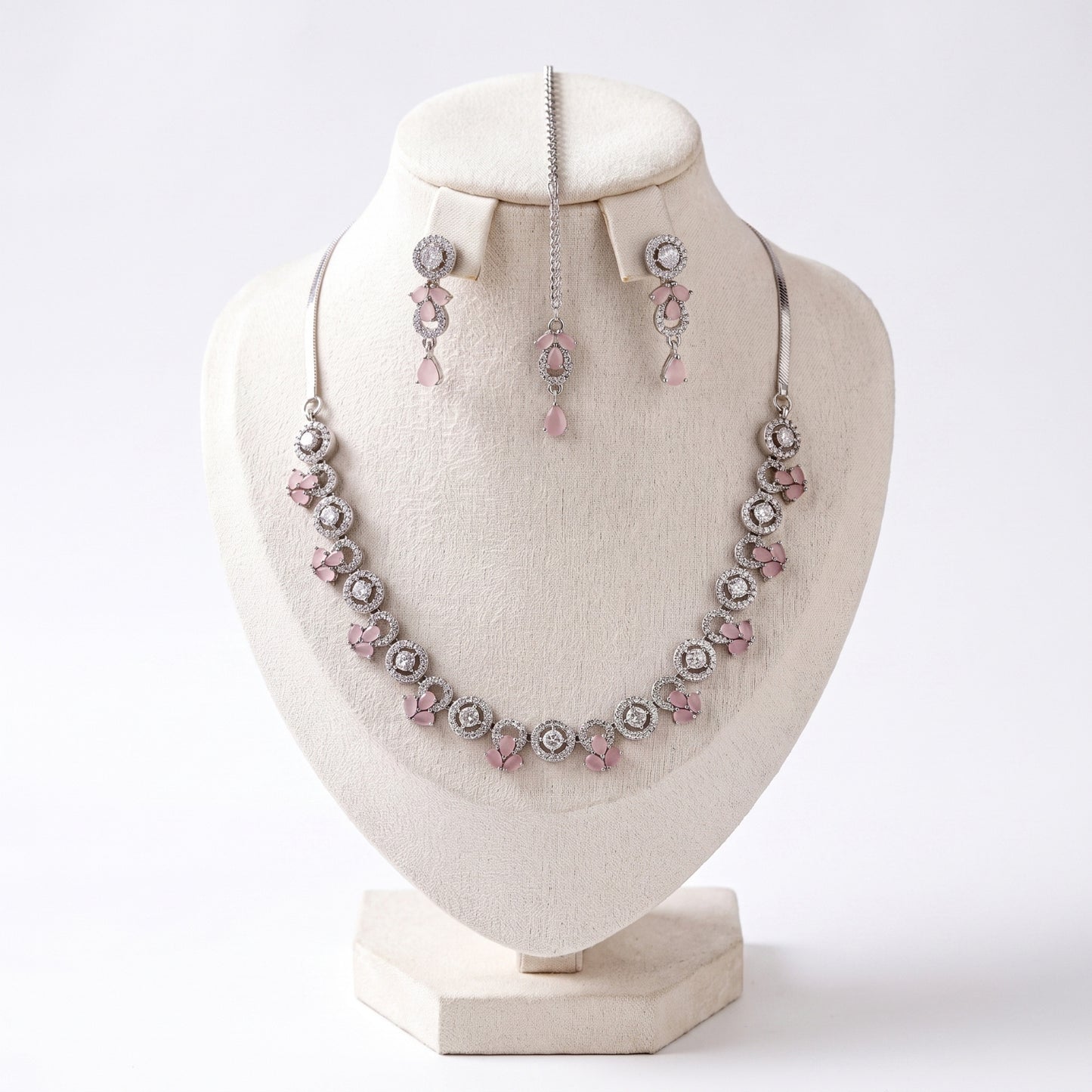 silver and baby pink necklace, earrings and tikka set arranged together showing soft pink tones