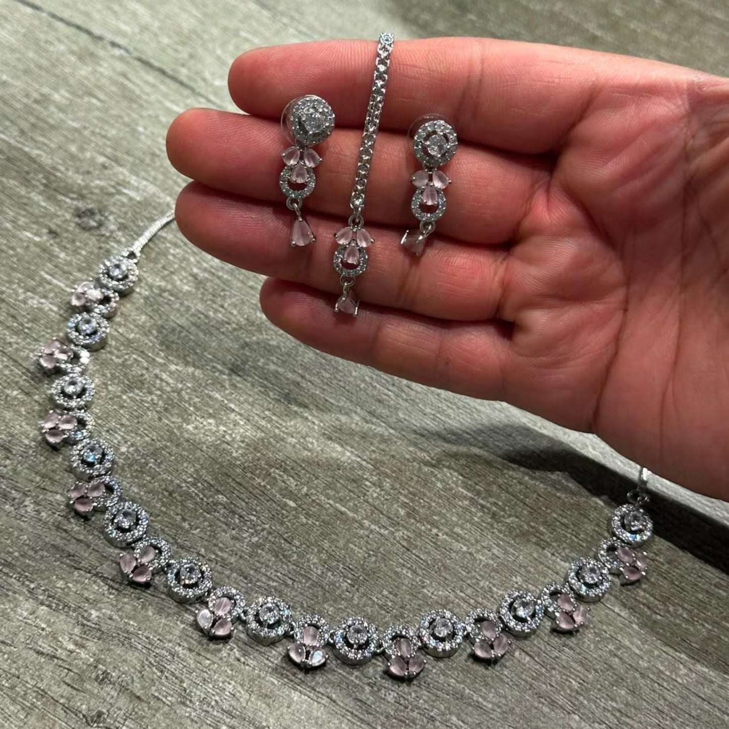 a mannequin showcases the silver and baby pink necklace set styled for a wedding celebration