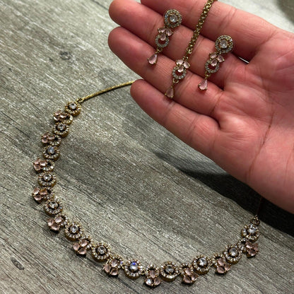 A closer view of the gold and baby pink necklace, showing its delicate stonework and finish