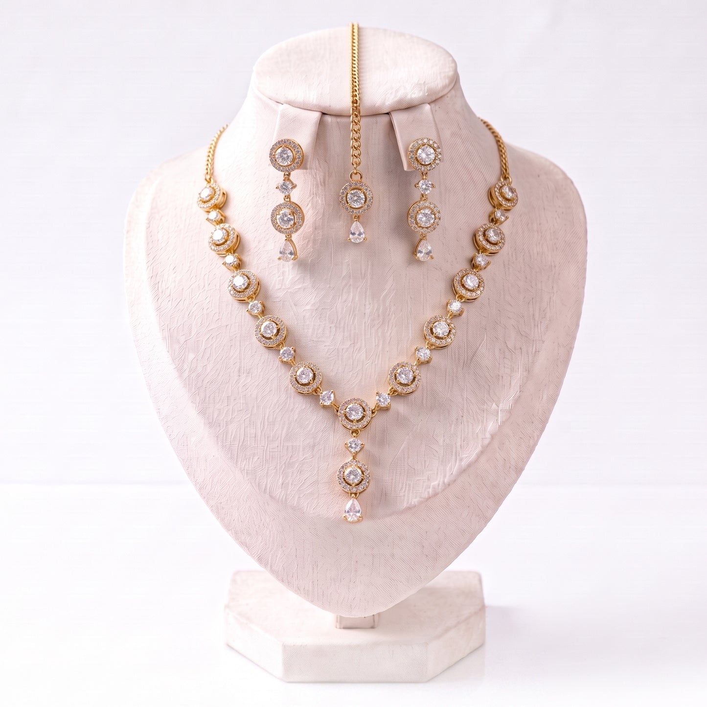 every piece of the simple gold and white necklace, earrings and tikka set laid out neatly together