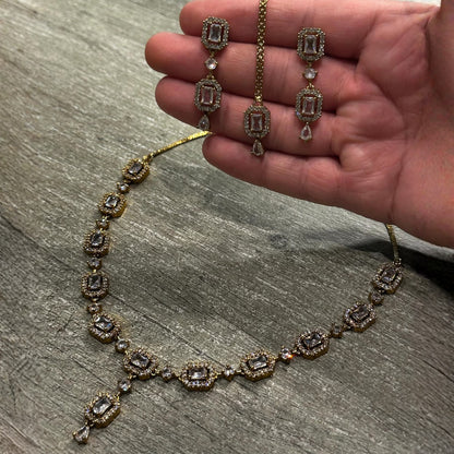 A closer look at the gold and white necklace, showing its fine detailing and polished metal finish
