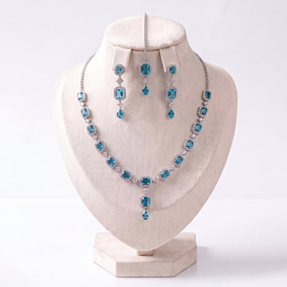 The Simple Light Blue Necklace, Earrings and Tikka Set laid out together on a plain backdrop
