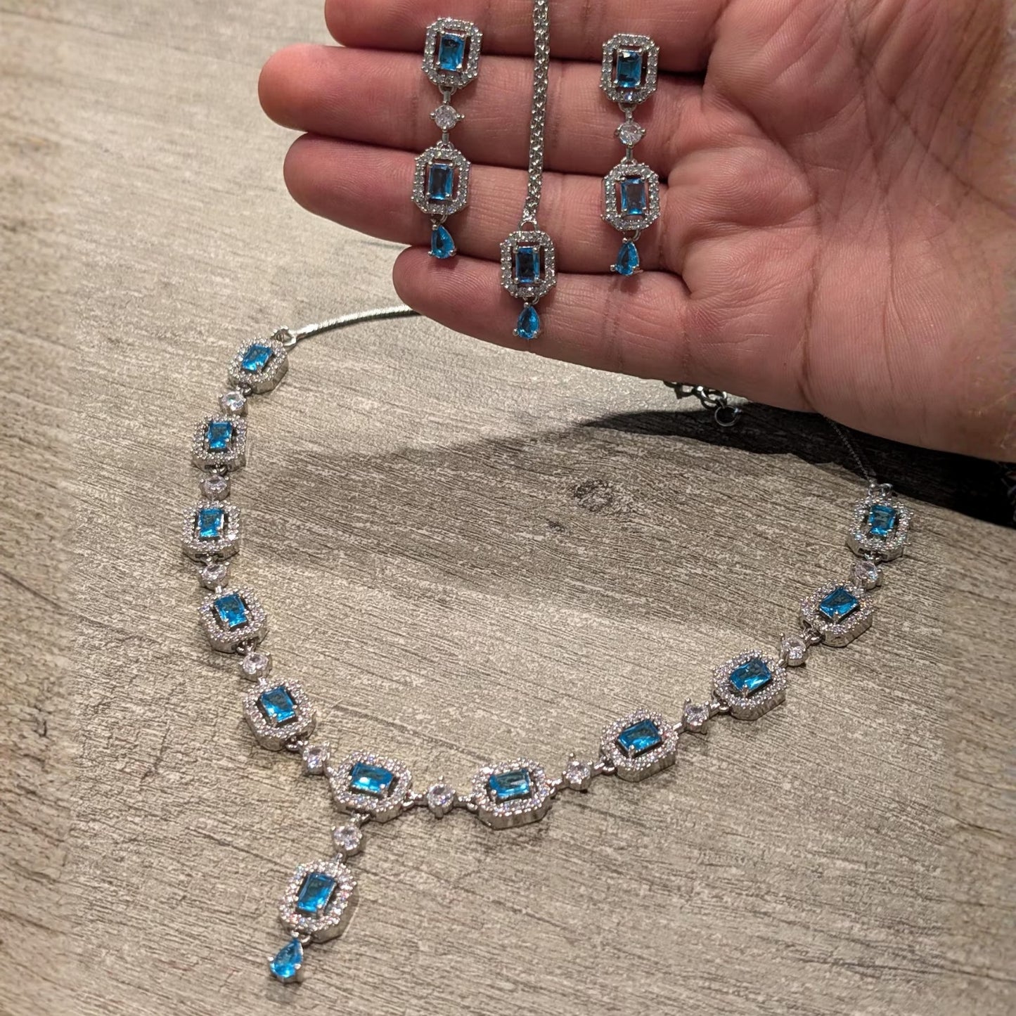 a closer look at the light blue necklace, showing the stonework and metal finish in detail
