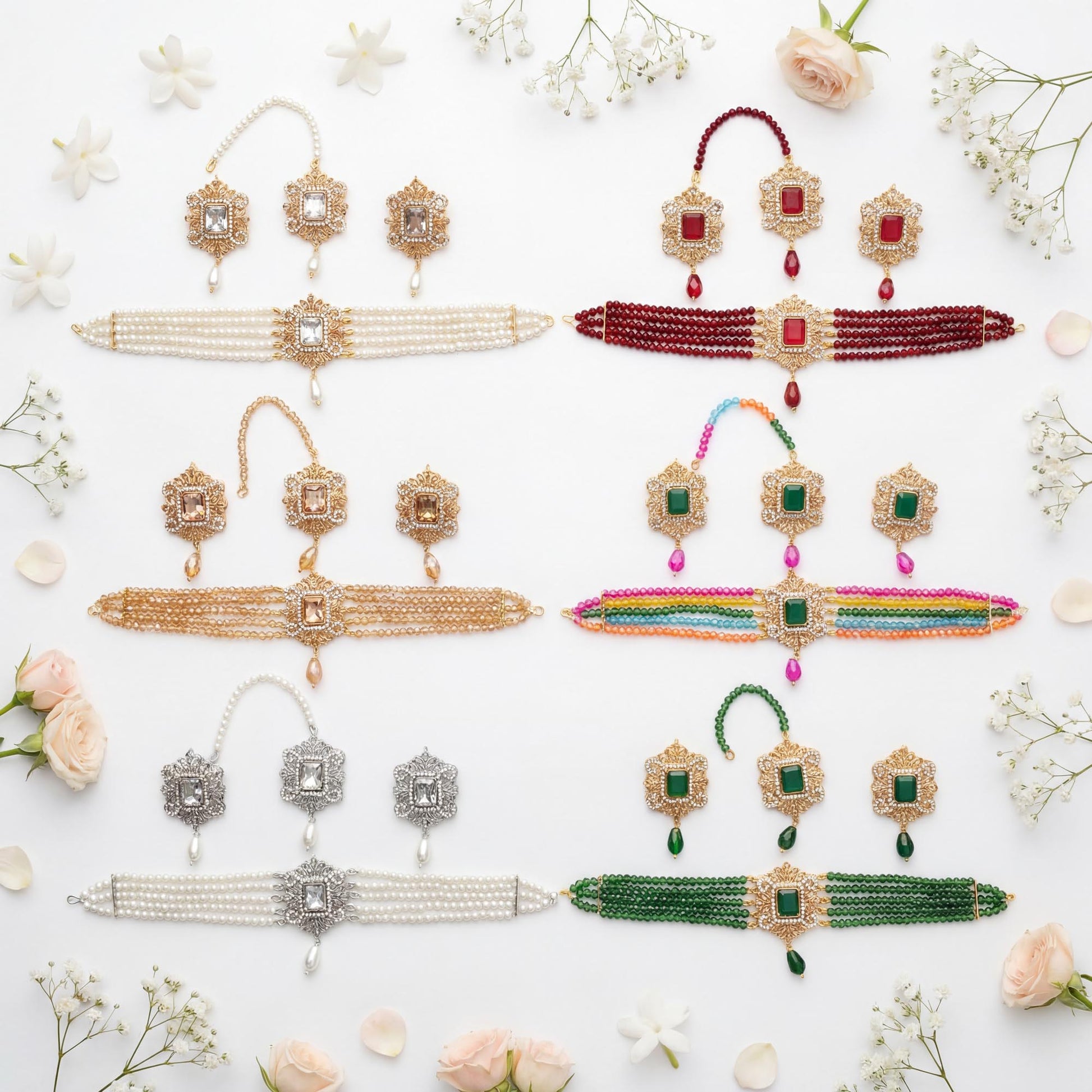 Collection of Pakistani choker sets including necklaces, earrings, and a maang tikka on a white background with flowers.