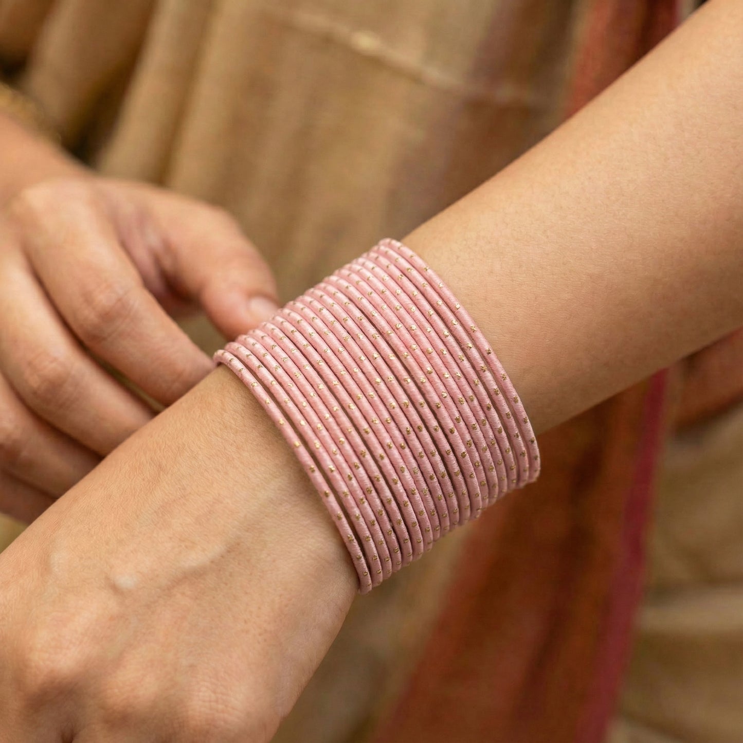 close-up of model wrist wearing baby pink bangles showing soft pastel colour and festive pakistani jewellery look indian jewellery