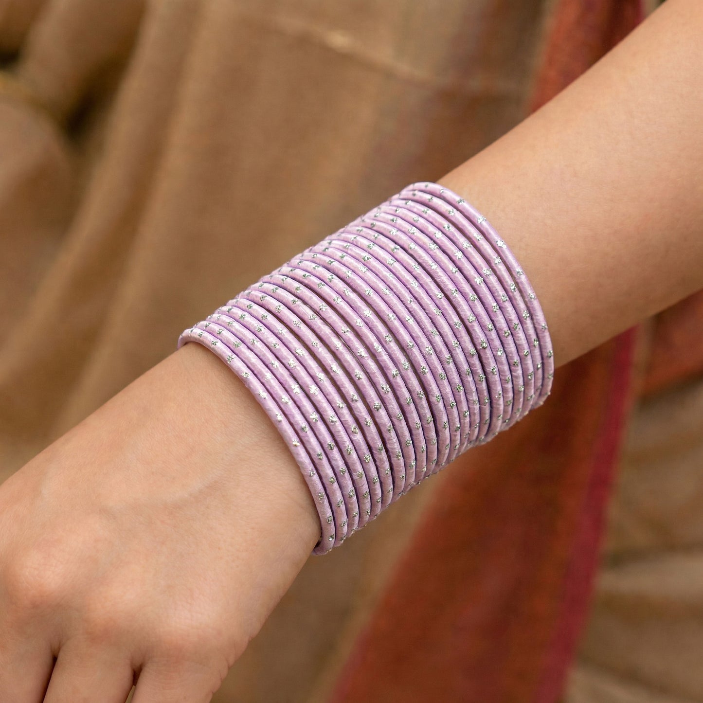model wearing baby pink bangles with silver dots churi set on wrist showing elegant indian bridal jewellery styling indian jewellery