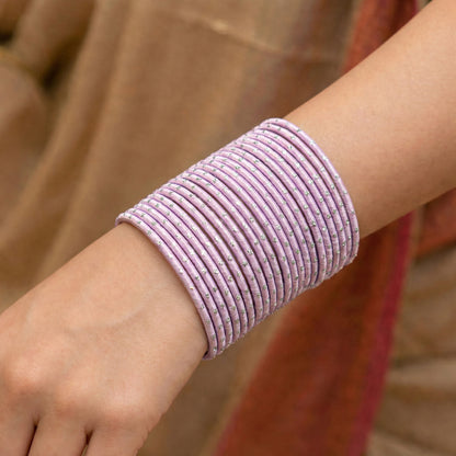 Model wearing baby pink bangles with silver dots churi set on wrist showing elegant Indian bridal jewellery styling indian jewellery