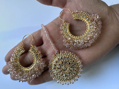 Goldand pink hoop earrings with gemstones held in a hand - trending Pakistani jewellery