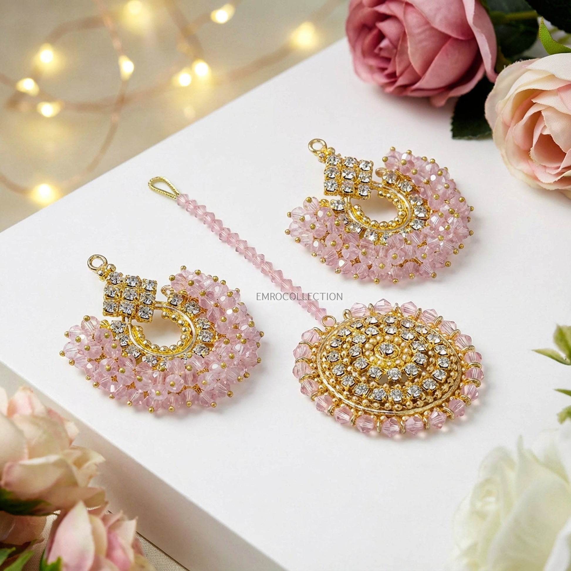 trending pakistani earrings tikka on a white surface with flowers and lights.