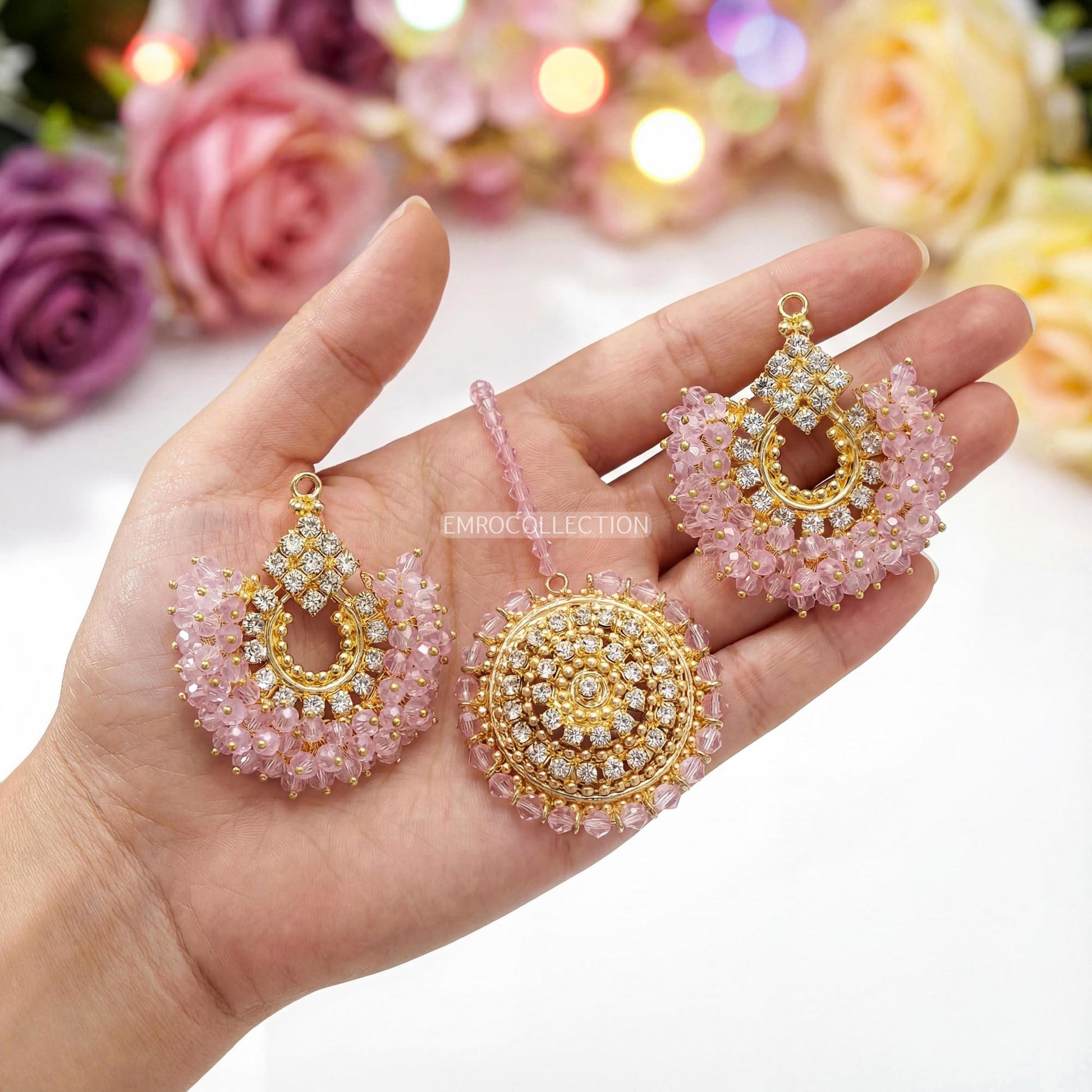 Hand holding gold and pink earrings tikka - trending pakistani jewellery