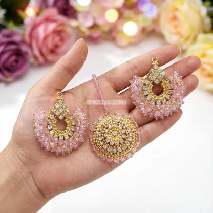 Hand holding gold and pink earrings tikka - trending pakistani jewellery