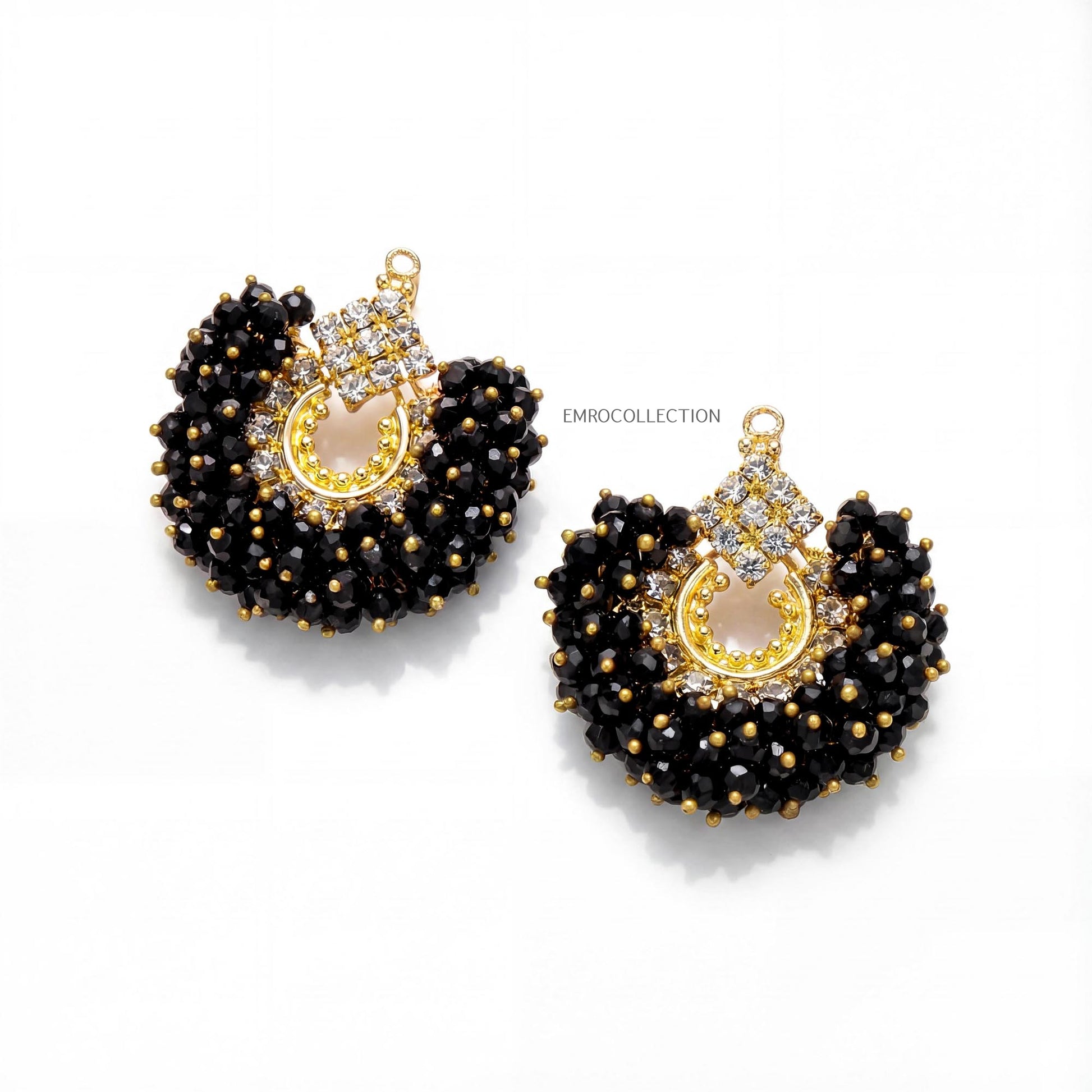 Pair of black beaded earrings with gold accents on a white background