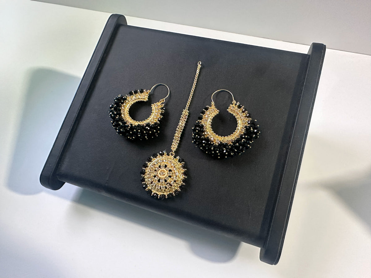 Elegant black Chand Bali earrings tikka set on a black display. trending pakistani jewellery