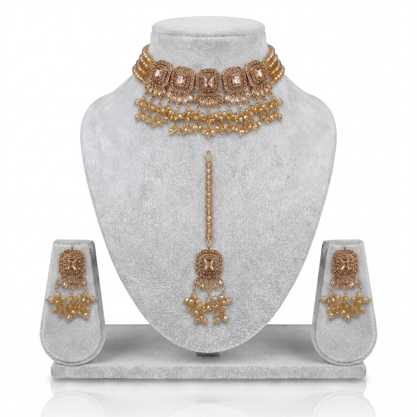 simple golden choker set with earrings and maang tikka displayed on a light grey velvet dummy – pakistani jewellery
