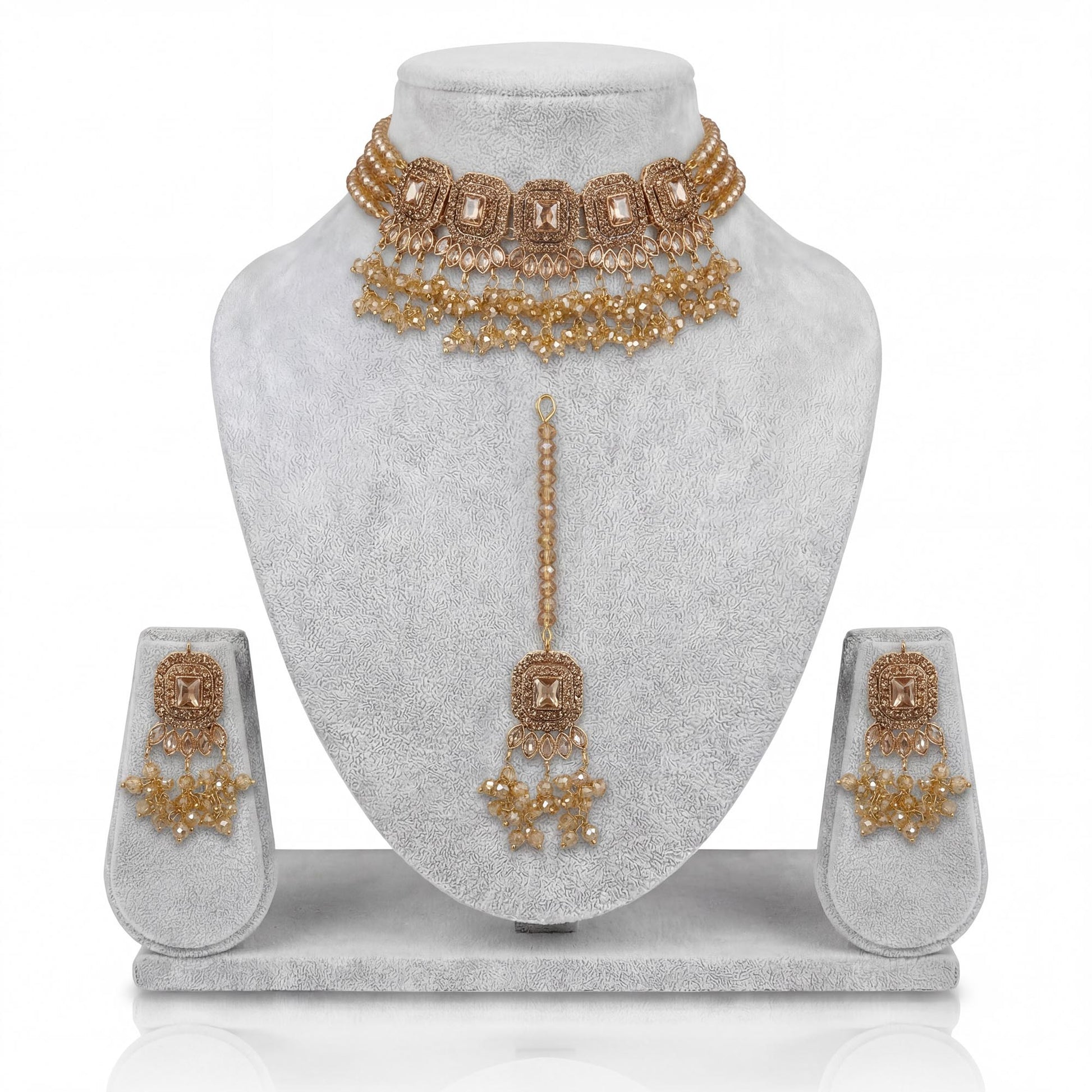 Simple golden choker set with earrings and maang tikka displayed on a light grey velvet dummy – pakistani jewellery
