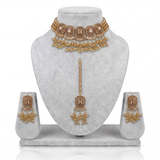 Simple golden choker set with earrings and maang tikka displayed on a light grey velvet dummy – pakistani jewellery
