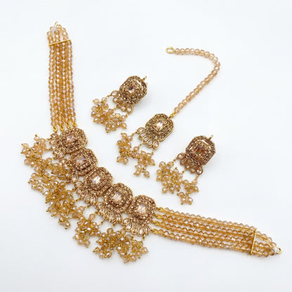 Minimal golden choker necklace set arranged on a pure white background for premium pakistani jewellery presentation