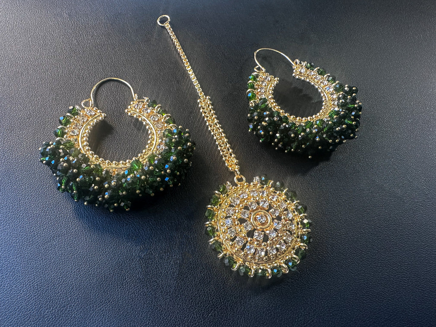 dark green chand bali earrings tikka set against a dark background - trending pakistani jewellery