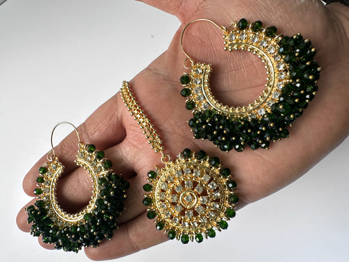 Gold and green chand bali earrings tikka held in a hand - trending pakistani earrings tikka 