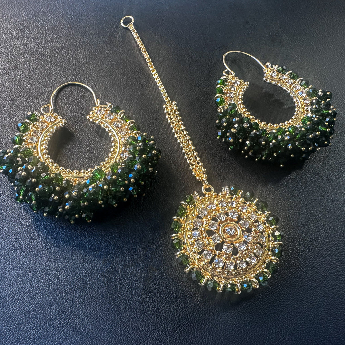 dark green chand bali earrings tikka set against a dark background - Trending Pakistani jewellery