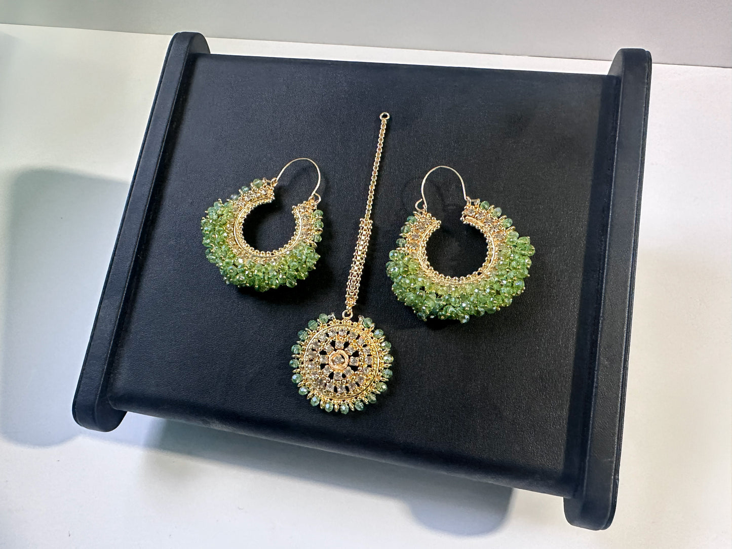 mint green earrings tikka on a black display. trending chand bali earrings tikka set