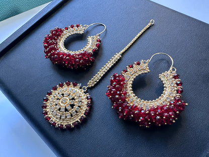 Side angle of maroon chand bali earrings tikka on a flat surface. Trending high quality pakistani jewellery