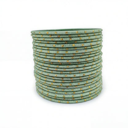 Mint green bangles with golden dots churi set arranged together showing slim elegant Indian jewellery design indian jewellery