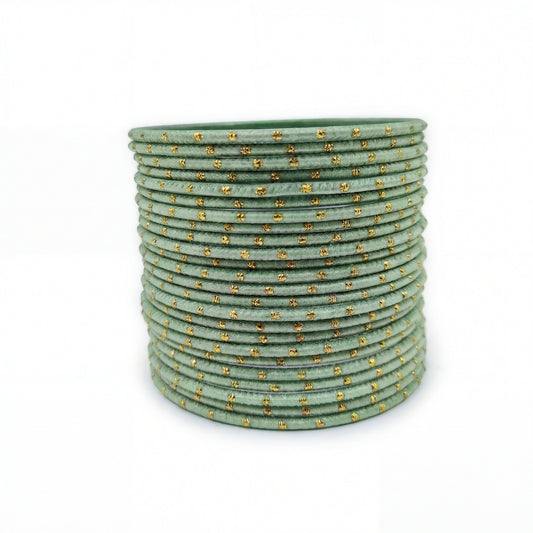 Mint green bangles with golden dots churi set arranged together showing slim elegant Indian jewellery design indian jewellery