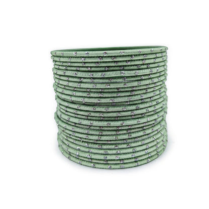 Mint green bangles with silver dots churi set arranged together showing slim elegant Indian jewellery design indian jewellery