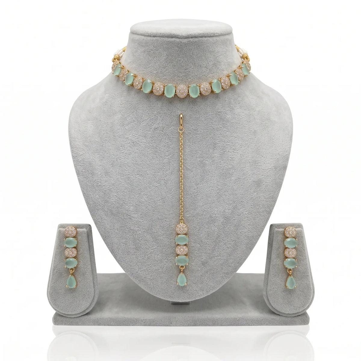 mint green choker set with earrings & maang tikka on a grey jewellery display