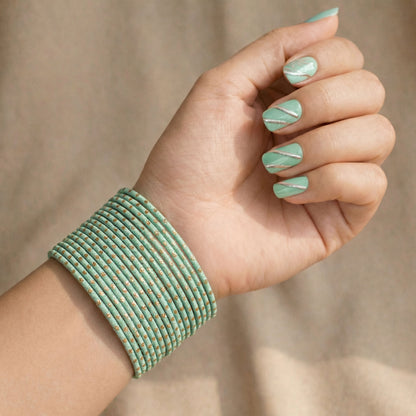 Model wearing mint green bangles with golden dots churi set on wrist showing elegant Indian bridal jewellery styling indian jewellery