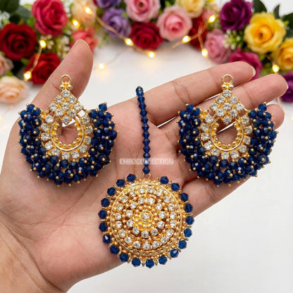 Gold and navy blue earrings tikka set held in a hand - sauitable for weddings and parties