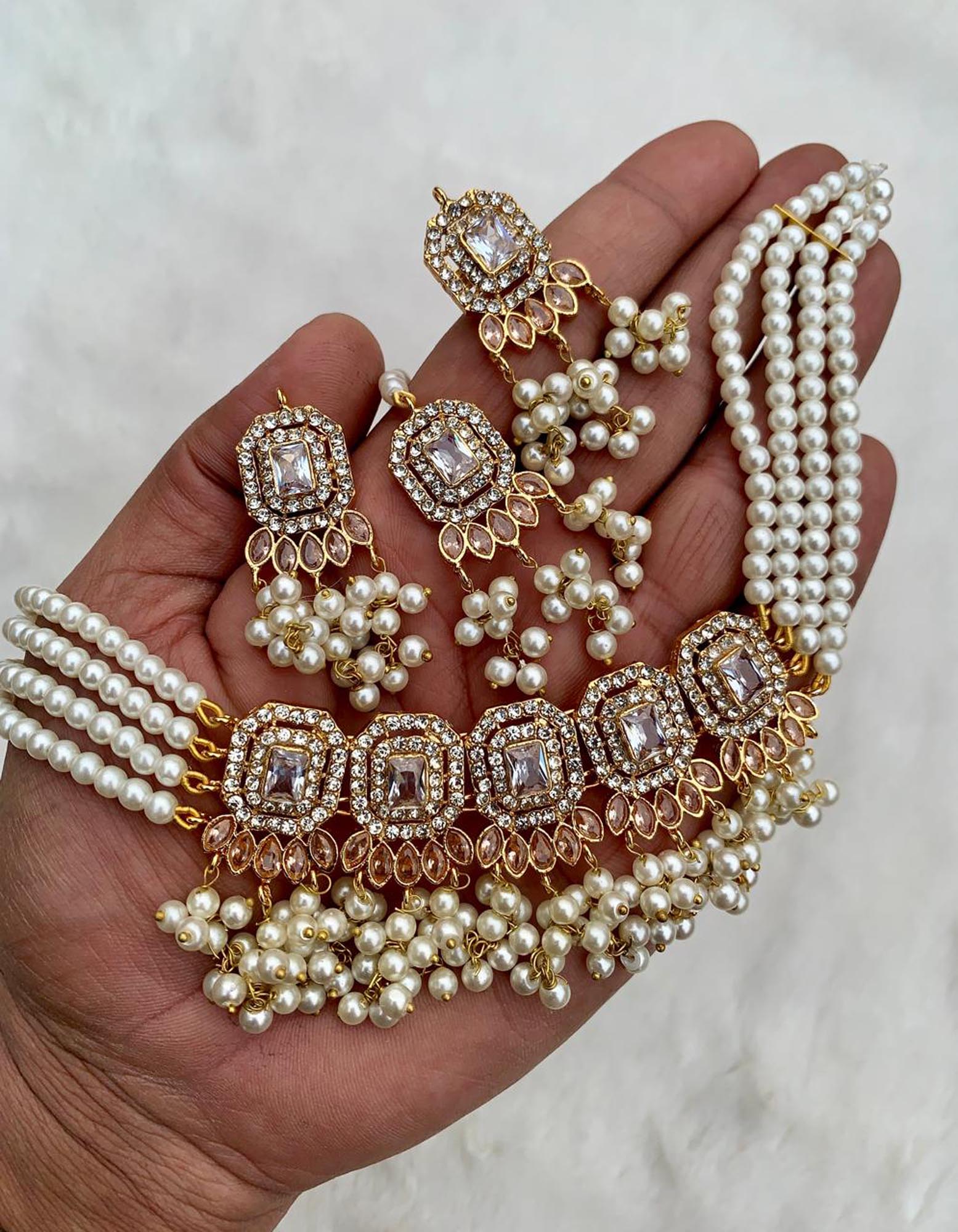 Hand holding off white pearl choker set for detailed close view of pakistani jewellery finishing