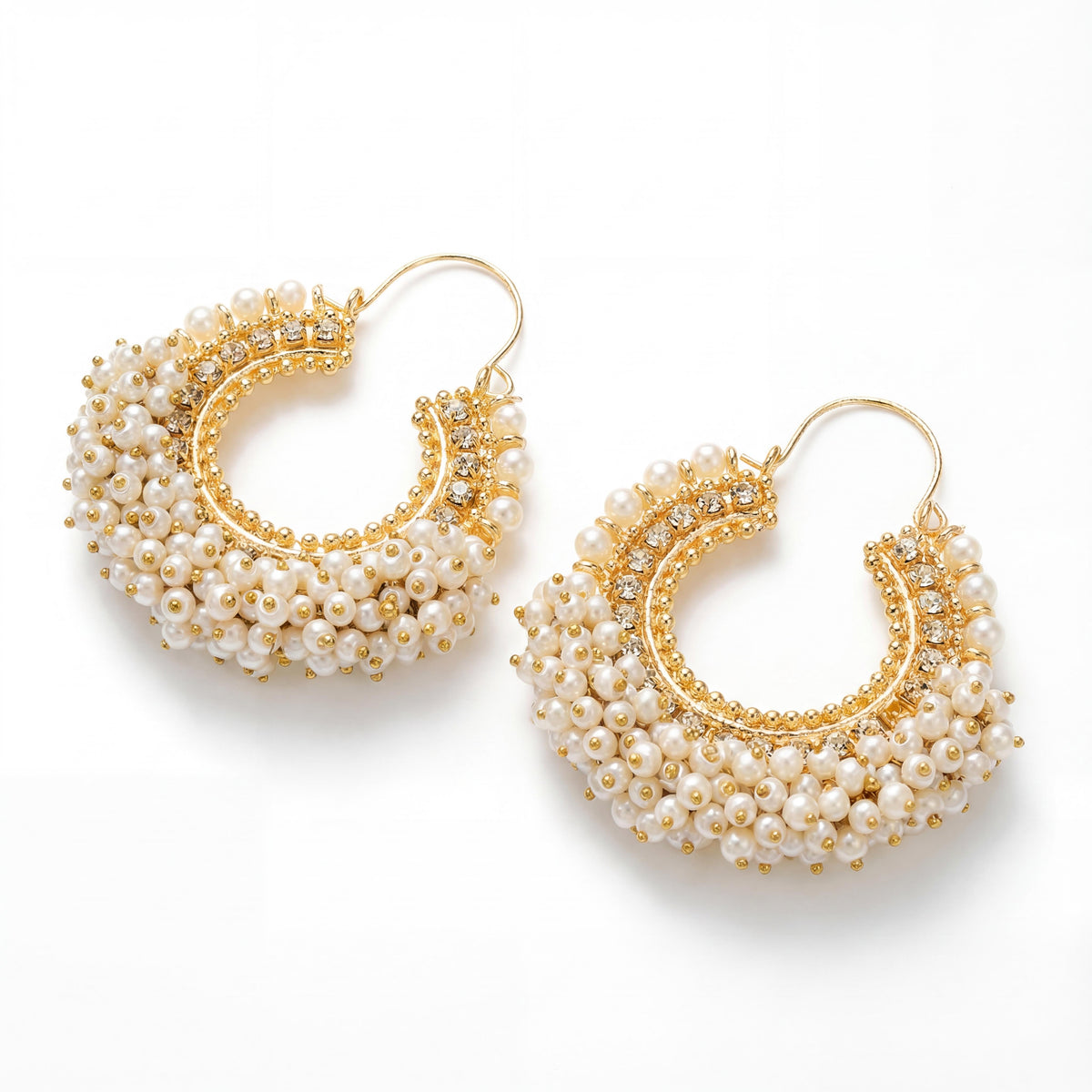 Gold and pearl hoop earrings on a white background