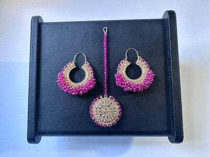 Vibrant shocking pink Chand Bali earrings tikka on a black display. Trending Pakistani jewellery. 