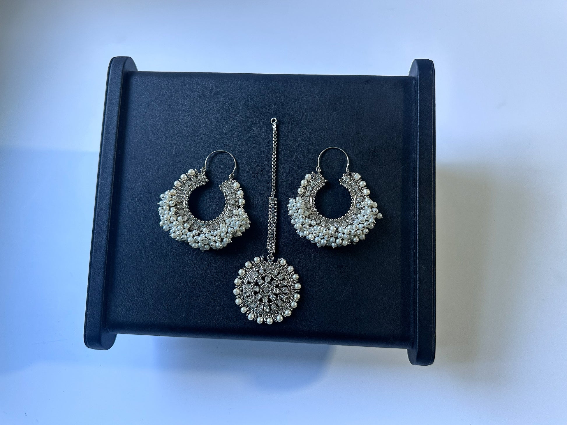 Pakistani style silver white Chand Bali earrings with tikka on a black display. pakistani trending earrings tikka