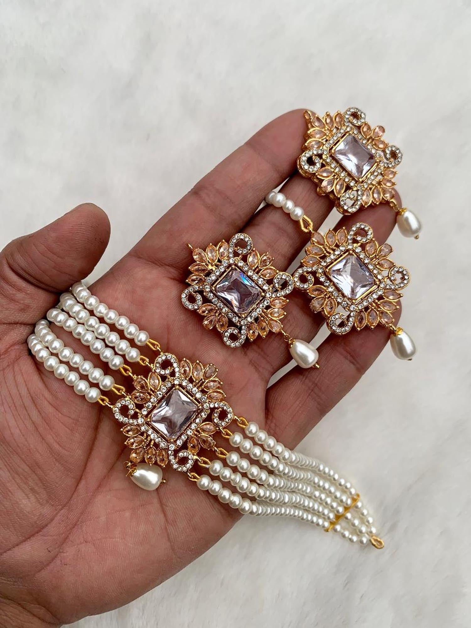 Hand holding off white pearl choker set for detailed close view of pakistani jewellery craftsmanship