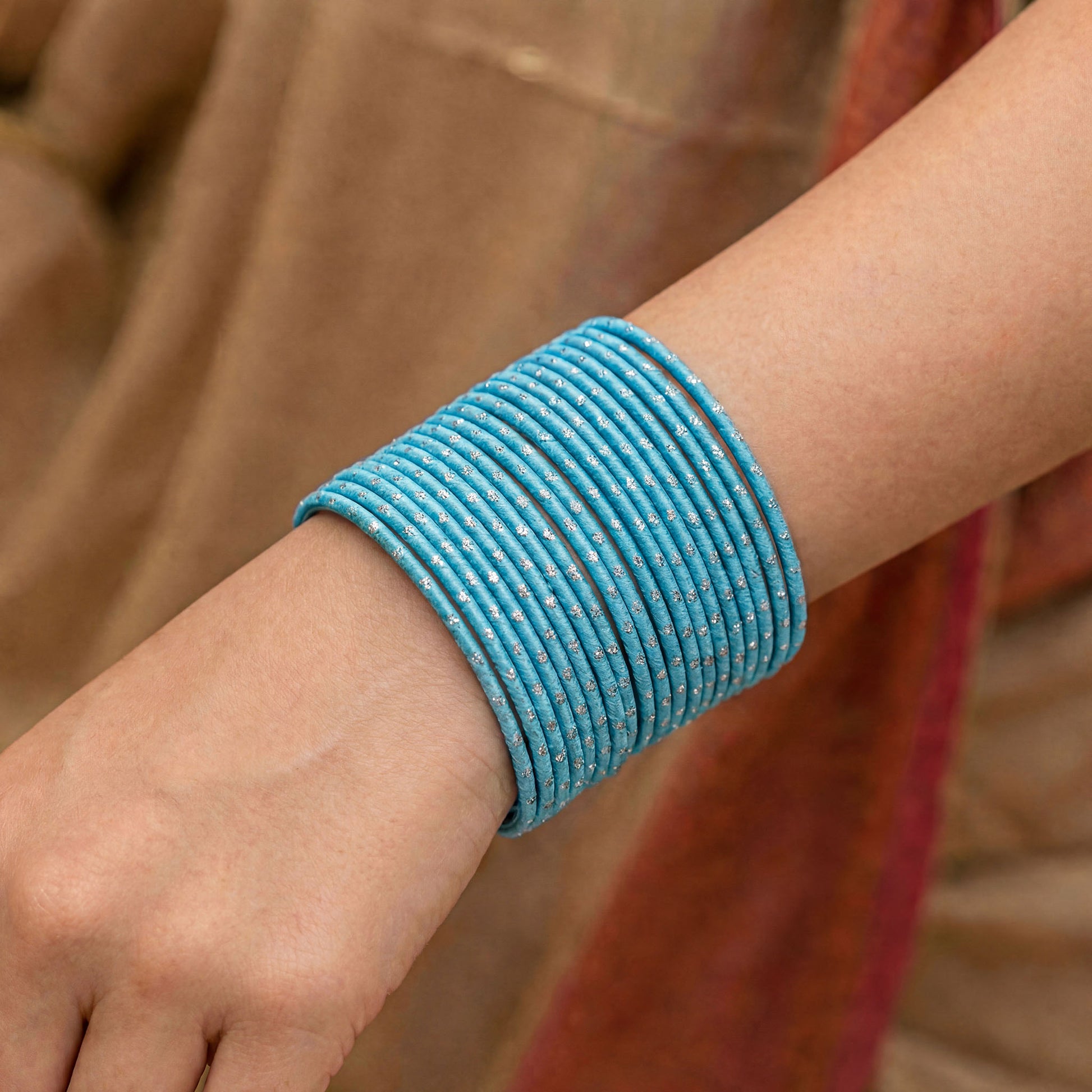 Close-up of model wrist wearing sky blue bangles with silver dots showing soft pastel colour and festive Indian jewellery look indian jewellery