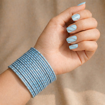 Model wearing sky blue bangles with silver dots churi set on wrist showing elegant Indian bridal jewellery styling indian jewellery